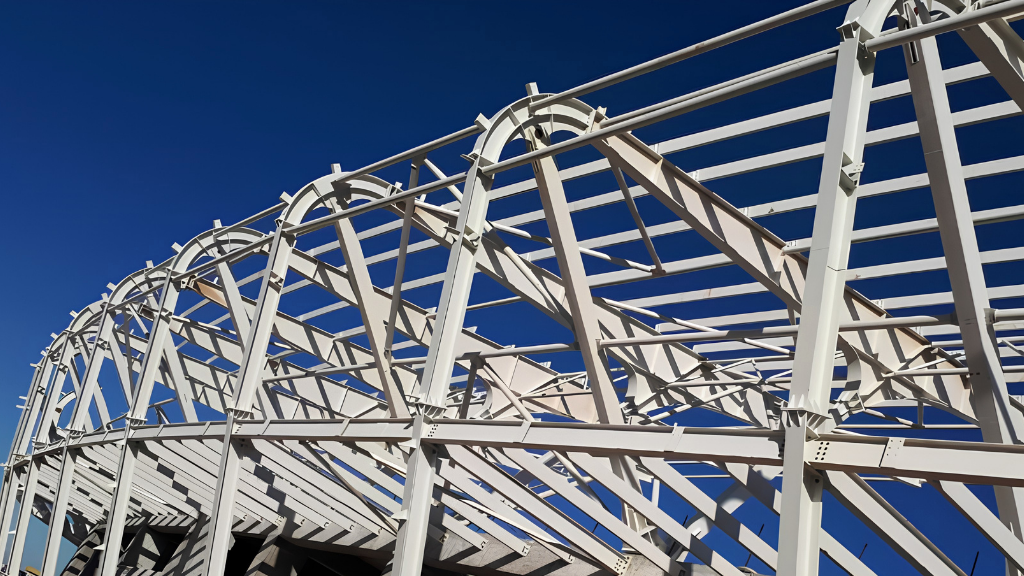 Long-span steel structure erection phase — primary beams positioned using the integral lifting method